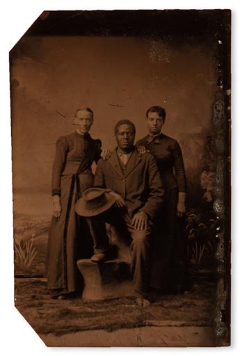 (PHOTOGRAPHY--EARLY AND CASED IMAGES.) A black man posed with two women; one white, the other possibly mixed.